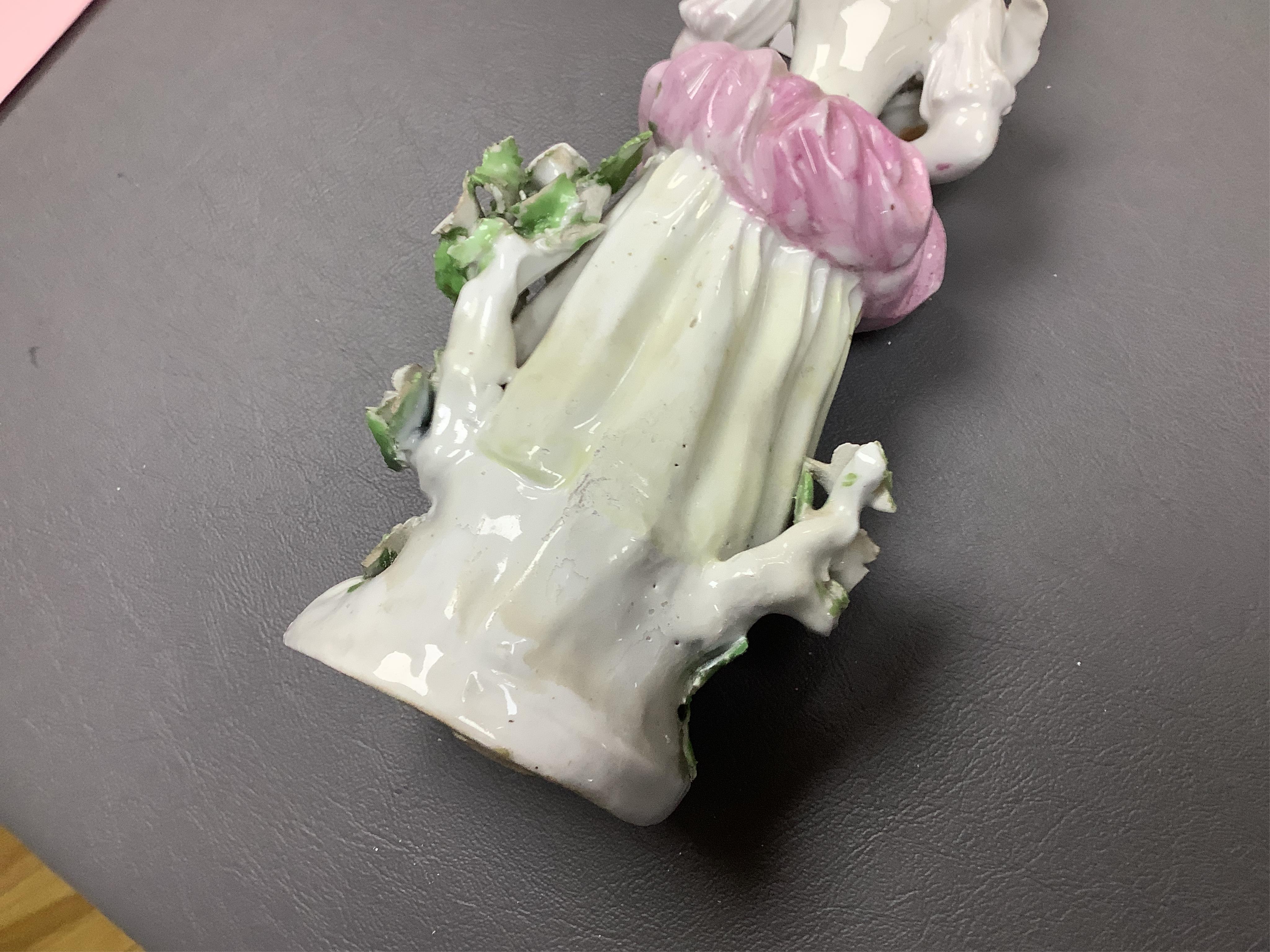 A Derby porcelain figure of a lady holding a bird, c.1760-65 and a Derby porcelain figure of a gentleman fruit seller, largest 24cm high (2)